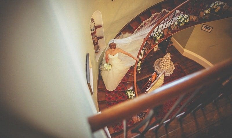 The bride walks down the spiral staircase in homme house