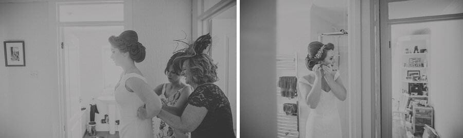 The bride is helped into her dress by her mother and a bridesmaid