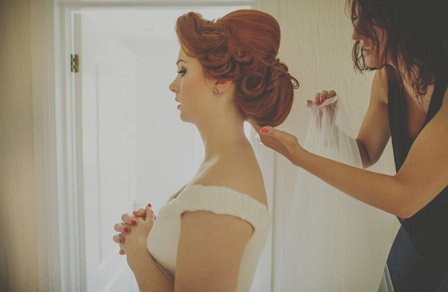 The make up artist puts on the brides veil