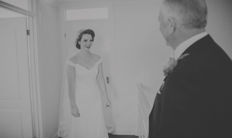The bride smiles as she sees her father for the first time