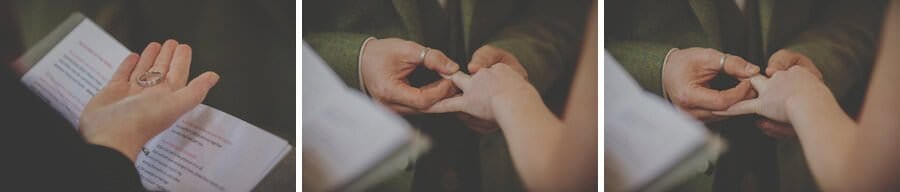 The groom places the wedding ring onto the finger of the bride