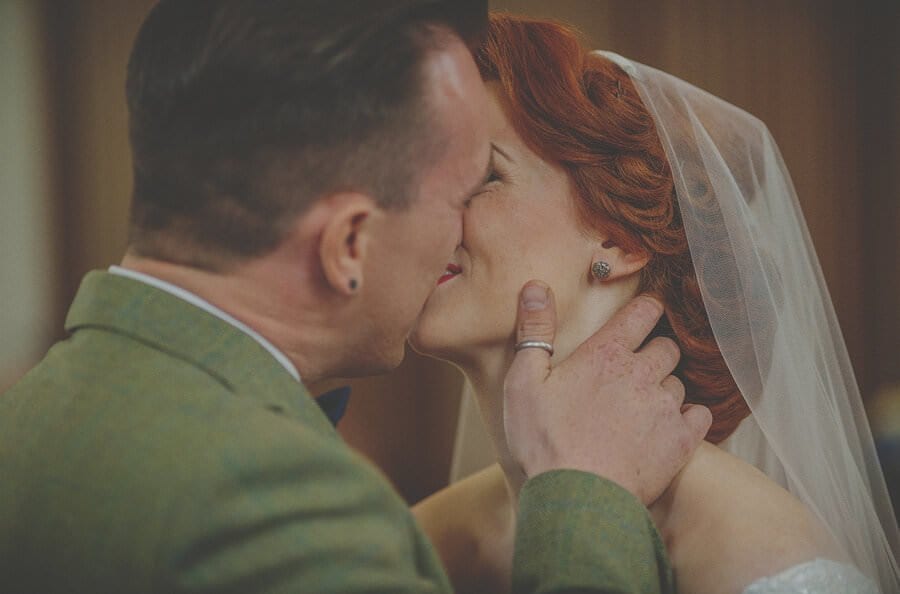 The bride and groom kiss each other during the wedding ceremony