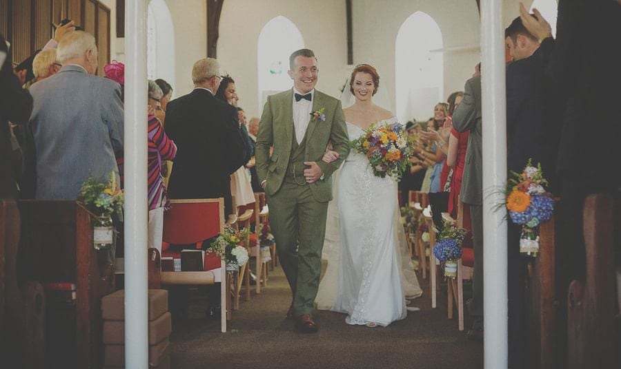 The bride and groom walk up the aisle together in church