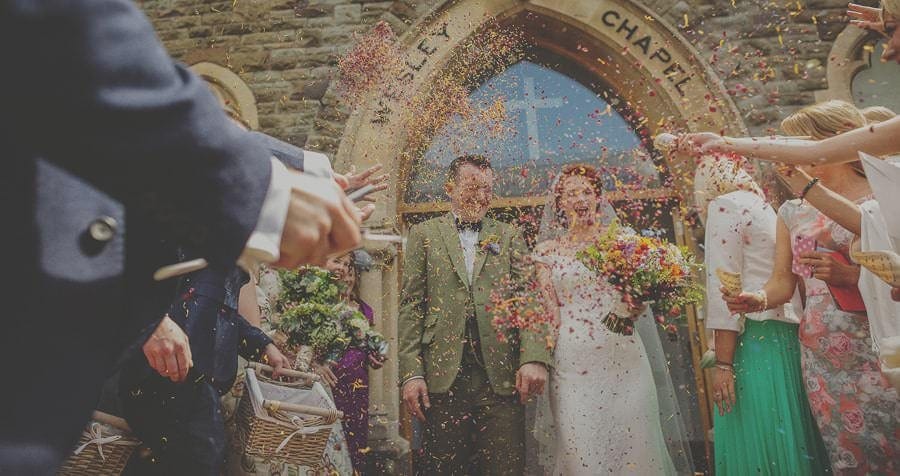 The bride and groom are showered with confetti