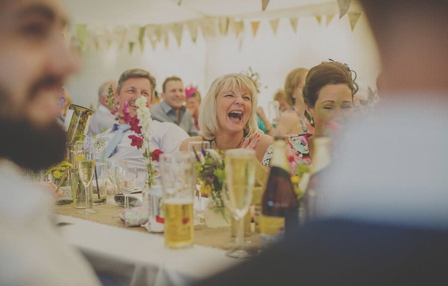 A wedding guest laughs in the marquee at Penmaen house