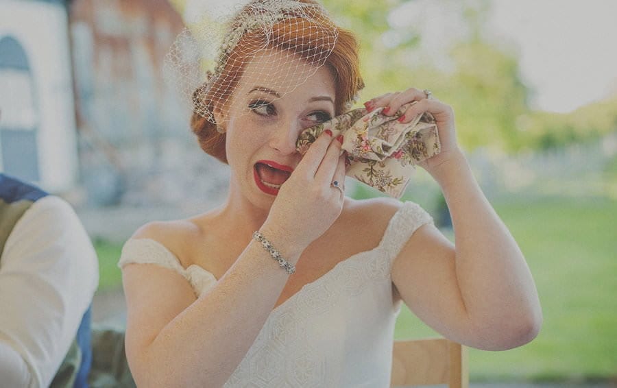 The bride wipes a tear from her eye