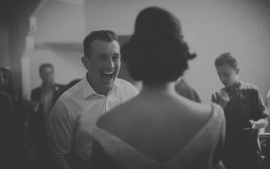 The groom laughs at his bride on the dancefloor