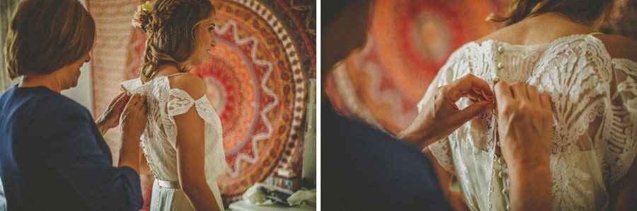 The brides mother fastens the buttons on the back of the brides dress