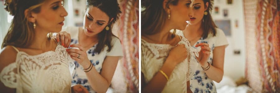 A bridesmaid fastens the left hand side of the brides dress