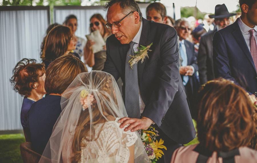 The brides father places his hands on his daughters shoulders