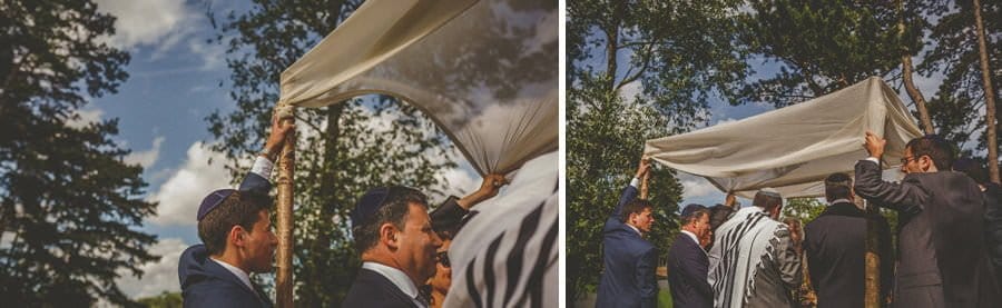 Wedding guests hold up the chuppah for the outdoor jewish wedding ceremony