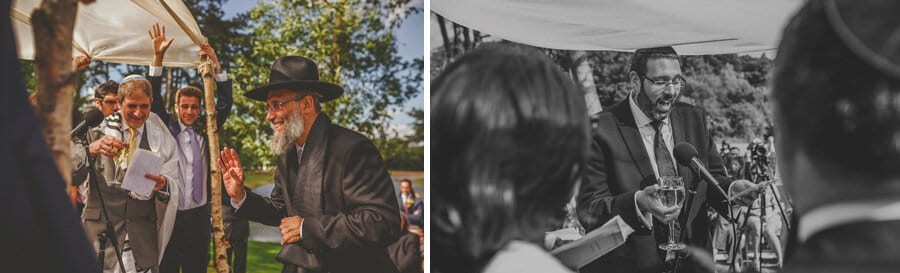 A man delivers his speech under the chuppah in front of the bride and groom