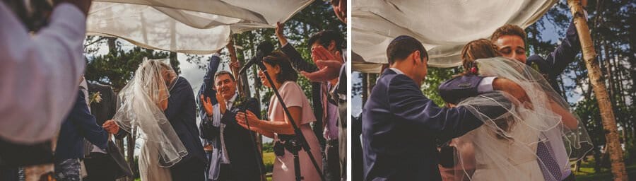 Wedding guests congratulate the bride and groom under the chuppah
