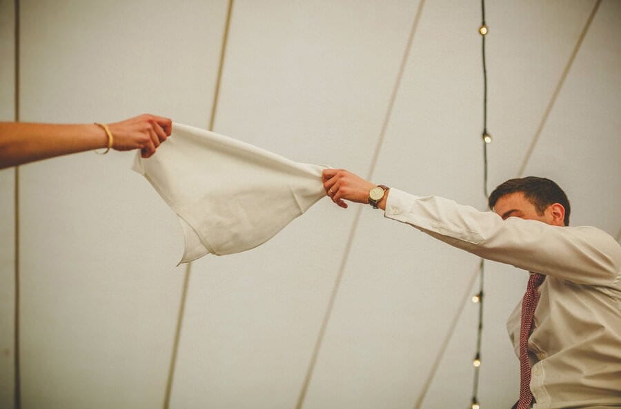 The bride and groom hold a handkerchief in the air