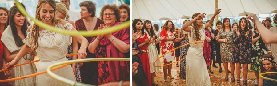 The bride spins hoops around her hips on the dancefloor in the marquee