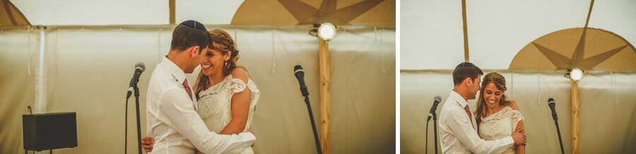 The bride and groom embrace each other in the marquee