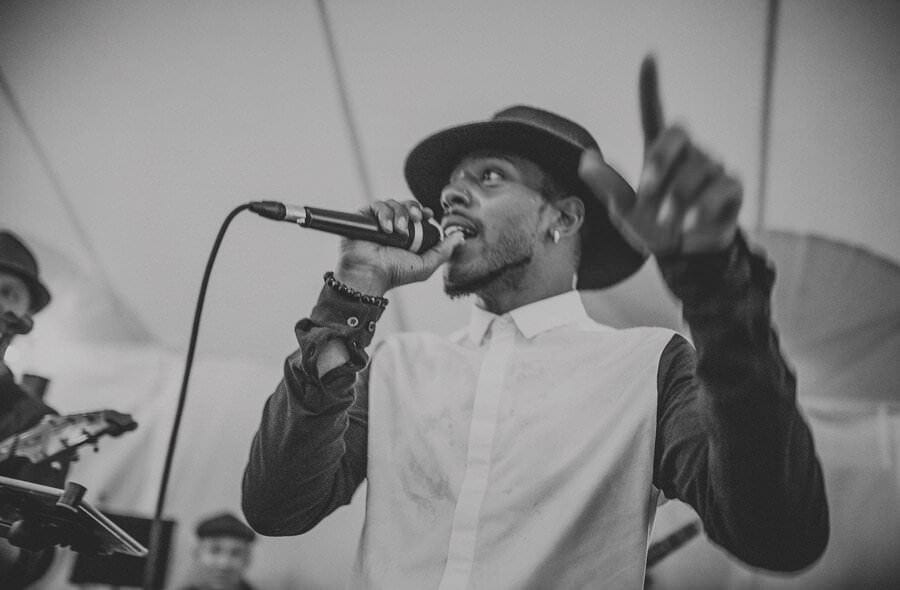 The singer of the wedding band on stage in the marquee