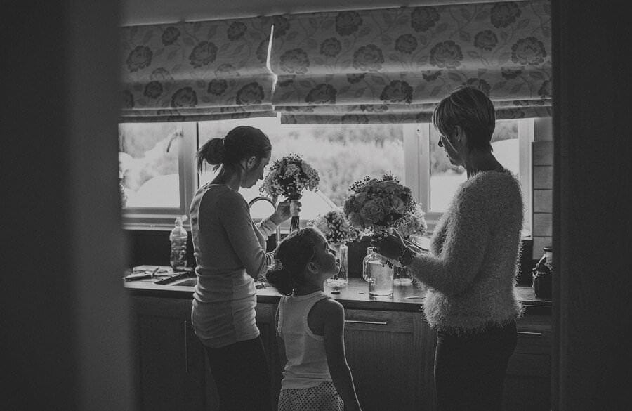 The family arrange the flowers in the kitchen