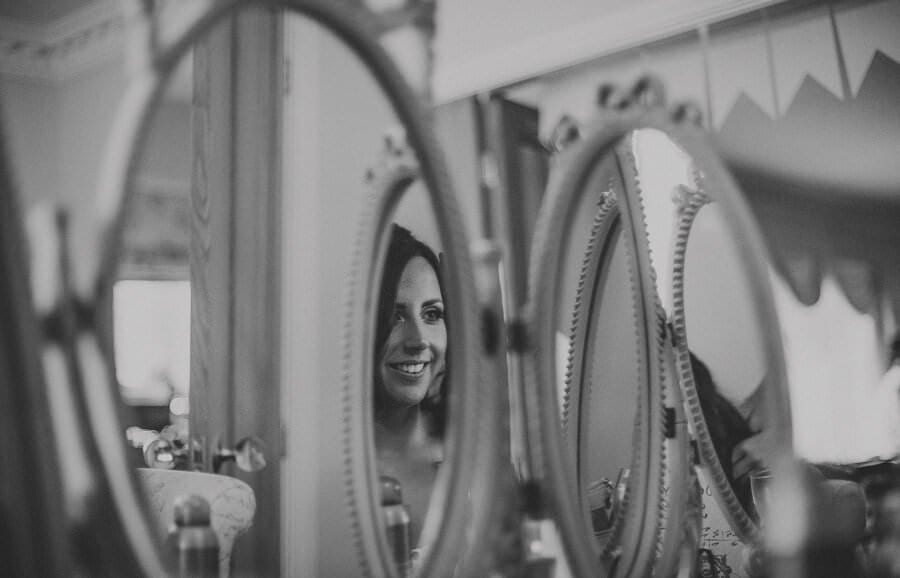 The bride looks in the mirror