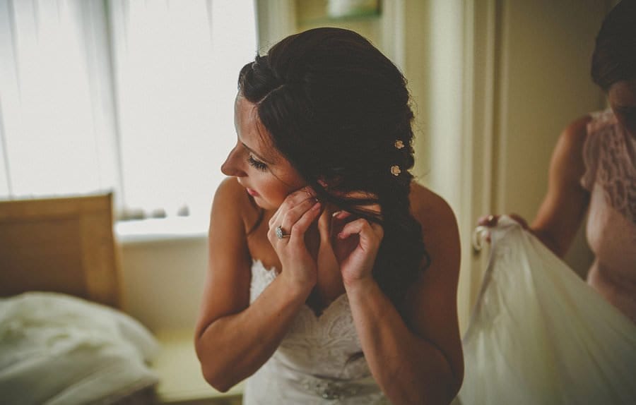 The bride puts on her earrings