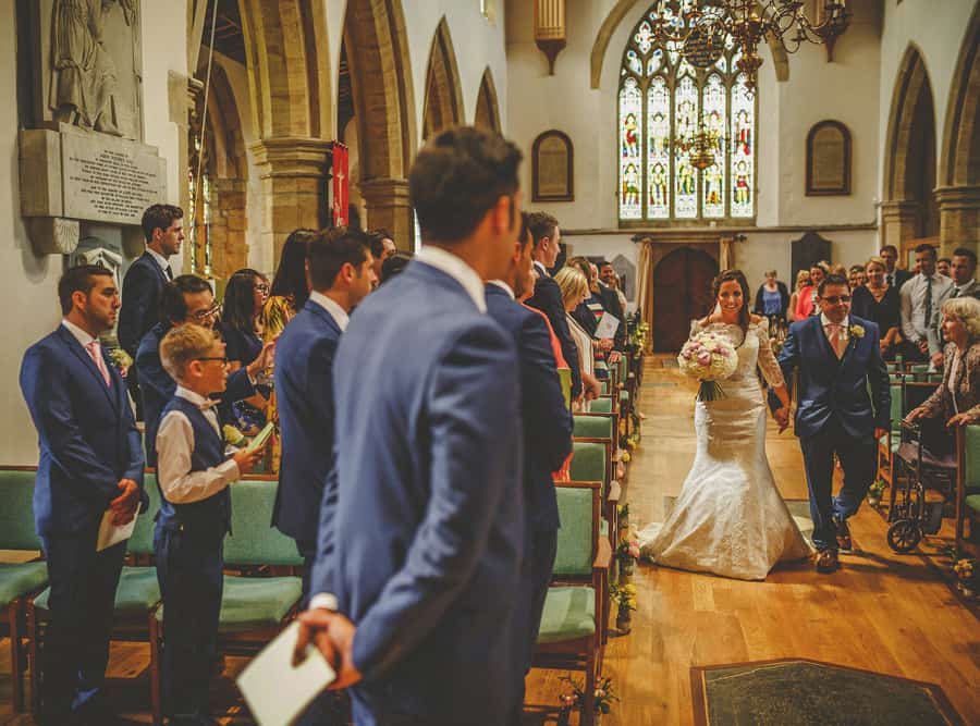 The bride walks down the aisel of the church