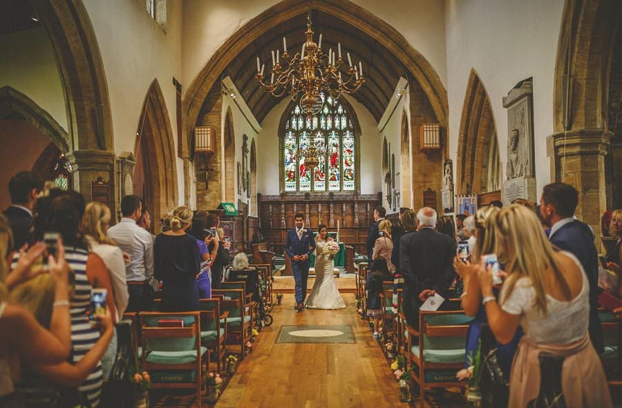 The bride and groom walk down the aise of the church