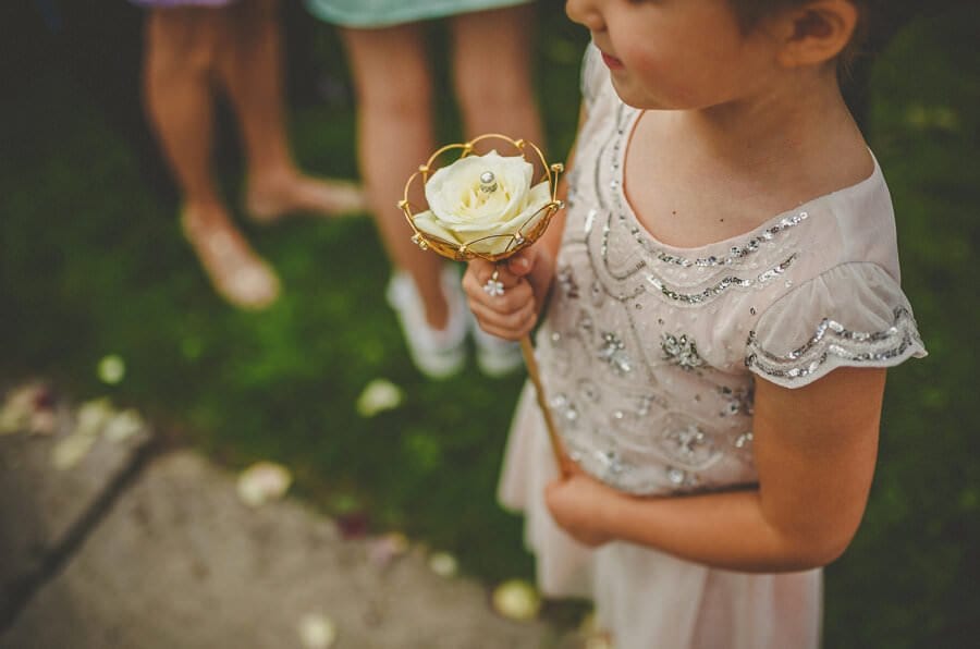 A flowergirl holds a flower outside the church
