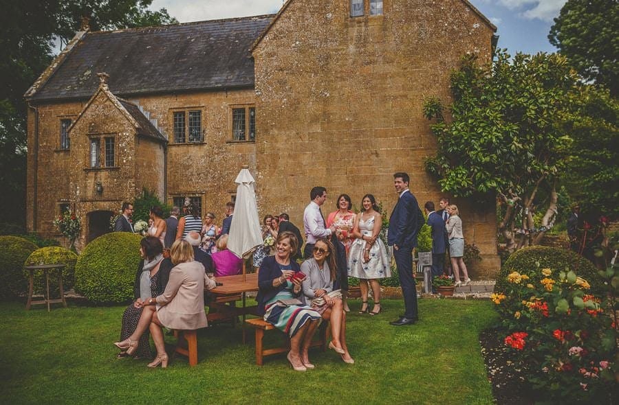 Wedding guests sit in the garden at the old bridge in petherton