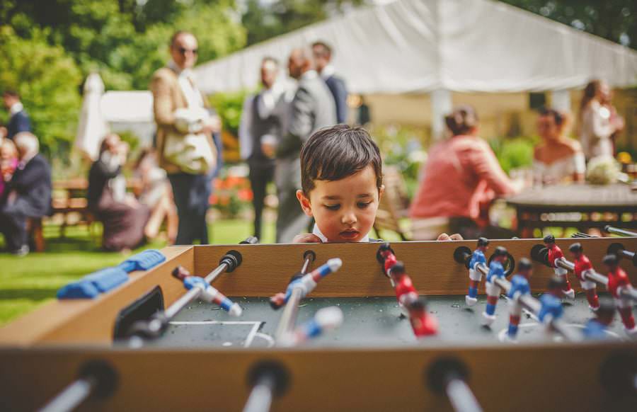 The grooms son looks at the table football in the garden