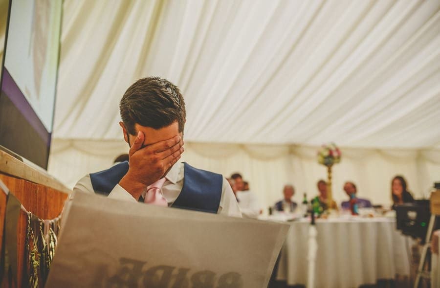 The groom holds his head in his hands