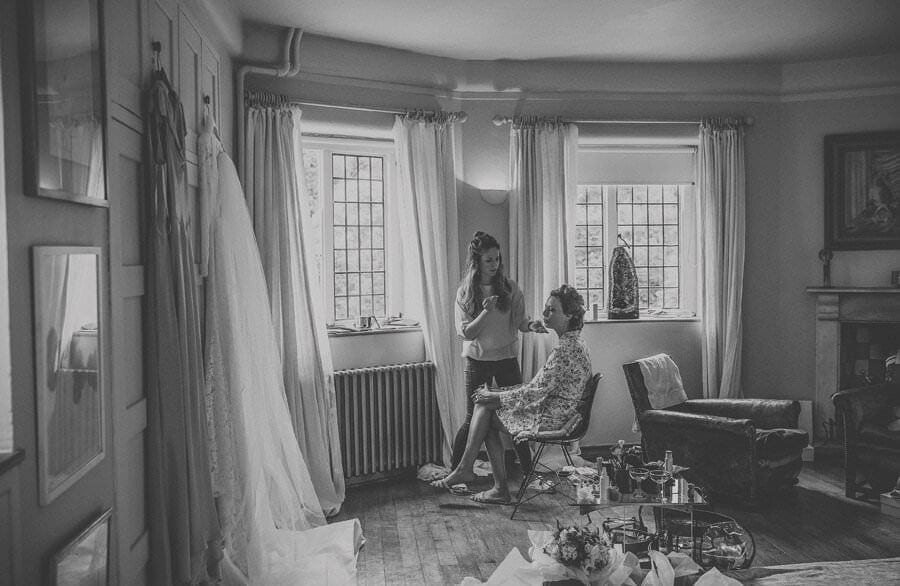 The make up artist applies mascara to the brides face