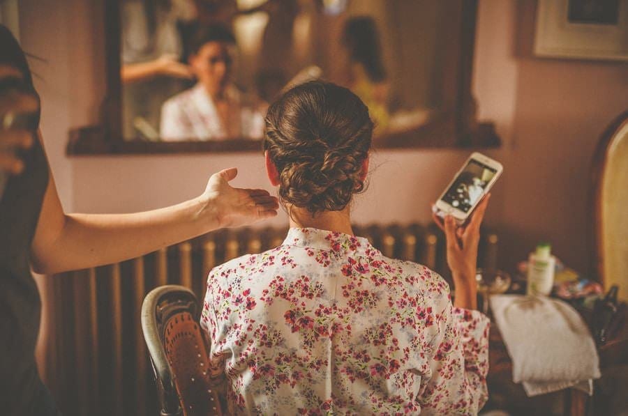 The hairdresser straightens the back of the brides hair