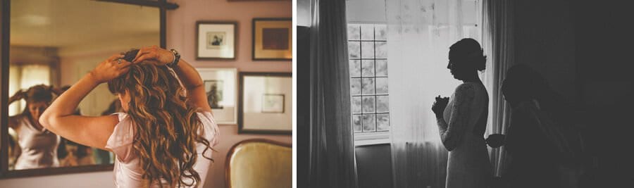 A bridesmaid fastens the back of the brides dress in the bridal suite