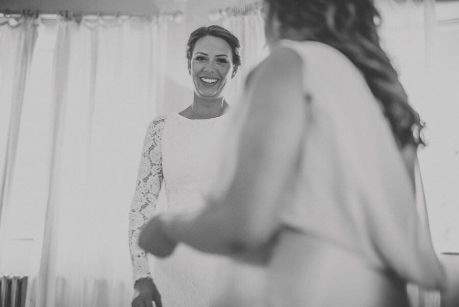 The bride smiles at a bridesmaid