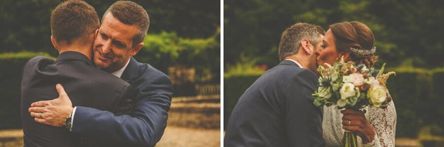 The groom and the bride embrace a wedding guest at the end of the wedding ceremony