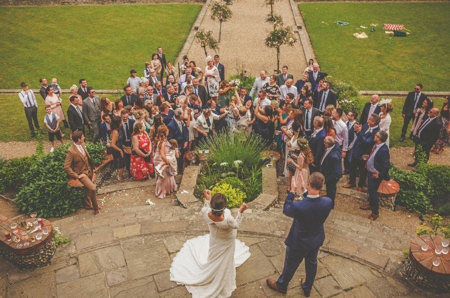 A wedding guest catches the bouquet thrown by the bride on the steps at Voewood