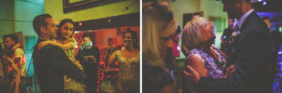 The groom holds a flowergirl in his arms on the dancefloor