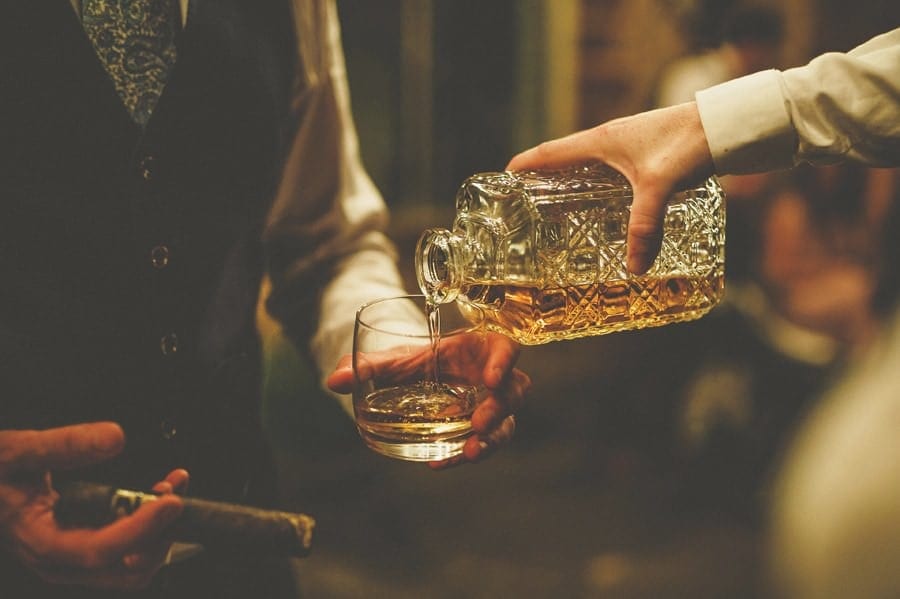 An usher pours whisky into a glass