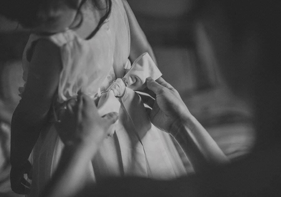 Fastening a bow to the flower girls dress