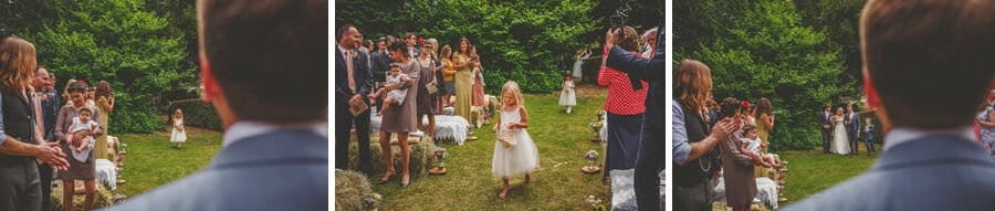 The flower girl drops rose petals along the way to the outdoor ceremony