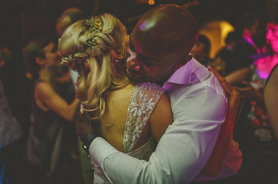 The bride embraces a friend on the dancefloor