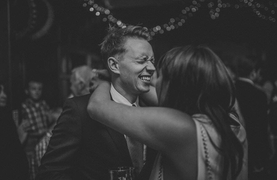 A member of the wedding party laughs with a lady on the dancefloor
