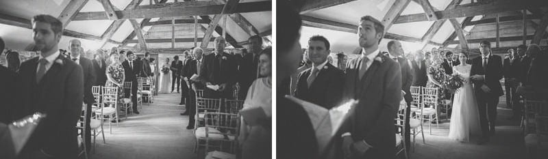 The bride and her father walk up the aisle together at Almonry Barn
