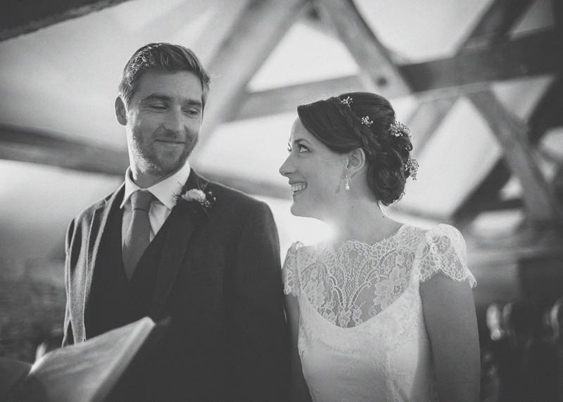 The bride and groom look at each other and smile at Almonry Barn