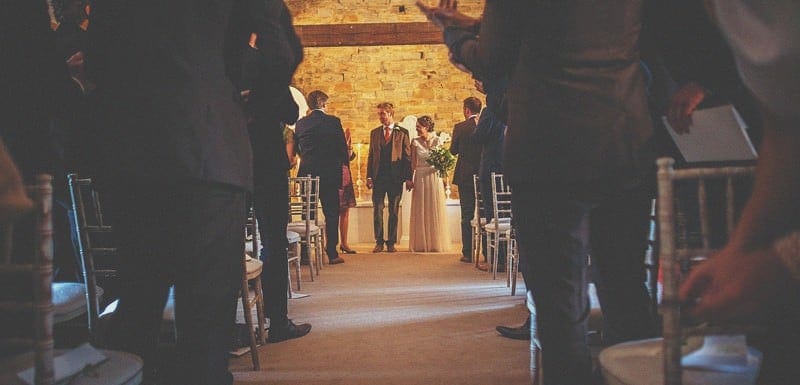 The bride and groom get ready to walk down the aisle together at Almonry Barn
