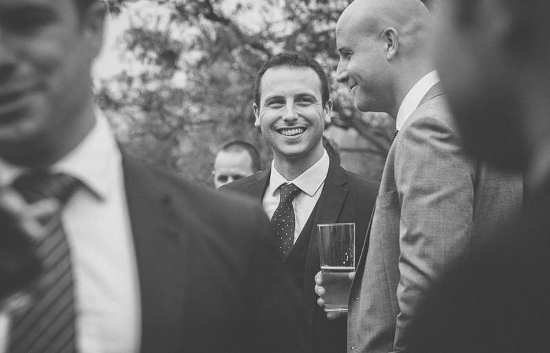 A wedding guest smiles at his friend