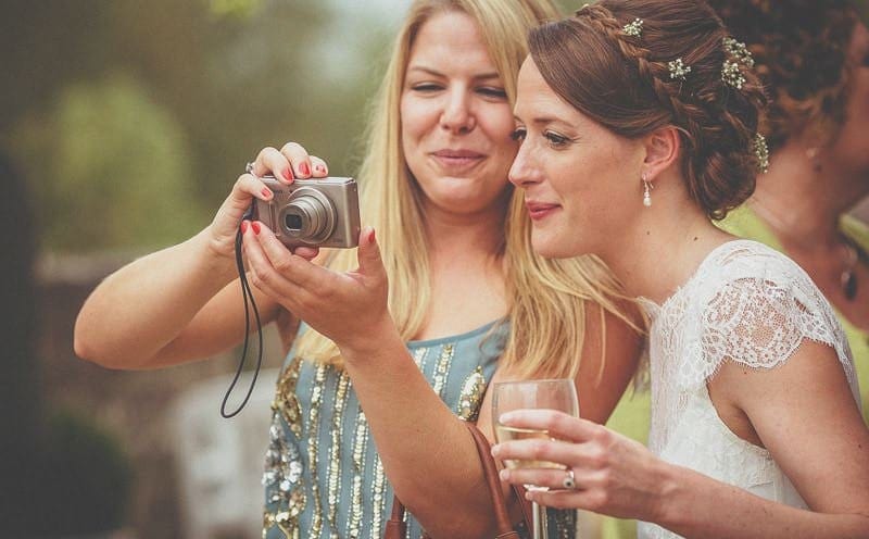 A wedding guest shows a photograph to the bride
