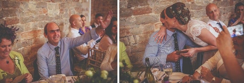 The bride walks across the barn and embraces a wedding guest