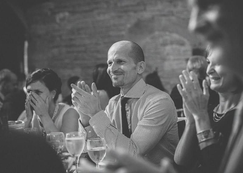 A man claps his hands after listening to the grooms speech