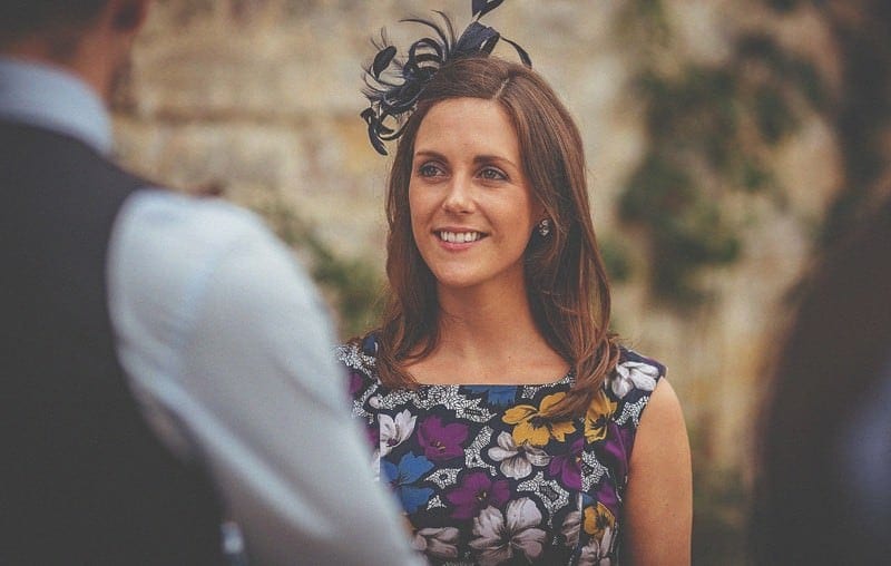 A wedding guest talks to friends on the lawn at Almonry Barn
